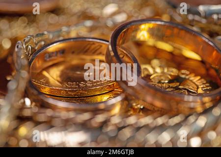 Gioielli d'oro, monete d'oro e barre d'oro in un primo piano Foto Stock