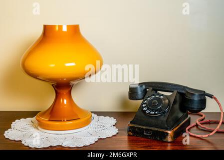 Interno. VVntage telefono e lampada su tavolo di legno. Foto Stock