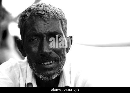 Vadodara, Gujarat - Novembre 19th 2022: Uomo indiano anziano primo piano faccia con pelle rugosa e capelli grigi buona e bella faccia fumo Foto Stock