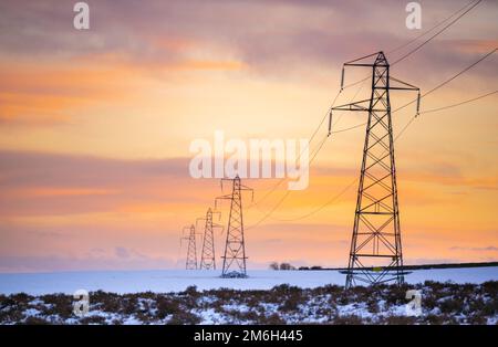 Vista sui piloni elettrici ai confini scozzesi. Foto in una fredda giornata innevata d'inverno. PIC Phil Wilkinson / Alamy Foto Stock