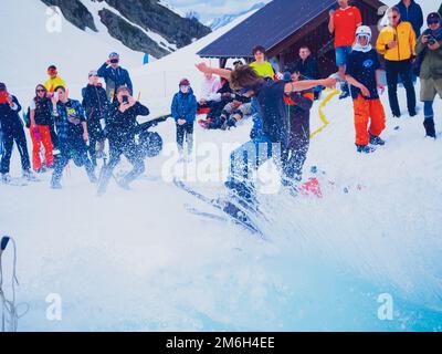 Russia, Sochi 11.05.2019. Un giovane ragazzo in maschera e sugli sci salta fuori dalla piscina con l'acqua fa un fresco feint, spruzzi volano dentro Foto Stock