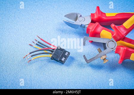 Spelafili isolanti set di pinze per fili elettrici su sfondo blu concetto di elettricità. Foto Stock