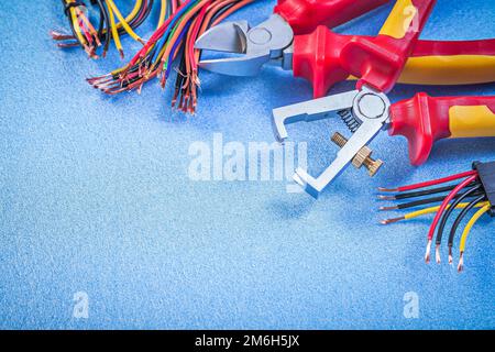 Spelafili isolanti set di pinze da taglio per fili elettrici su sfondo blu concetto di elettricità. Foto Stock