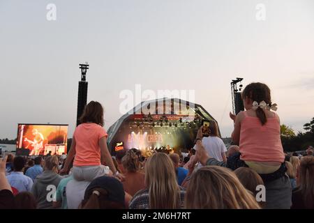 I bambini sedettero sui loro houlders dei genitori che guardano i Kaiser Chiefs esibirsi sul palco al giorno 2019 delle forze Armate, Salisbury - Hudson’s Field, 29 giugno 2019 Foto Stock