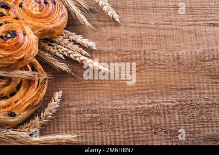 Spighe di grano mature conigli dolci di uva passa su tavola di legno di legno di oaken cibo e bevande concetto Foto Stock