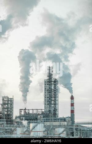 Il lavoro di un impianto petrolchimico. Il fumo proviene dal camino. Foto Stock