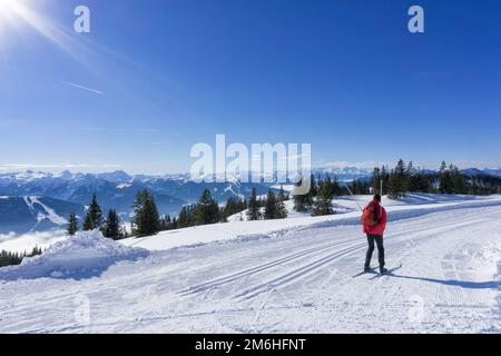 Paesaggio montano invernale, giornata di sole nelle Alpi di Salisburgo. Sciatore di fondo singolo su piste ben curate in cima al Monte Rossbrand. Foto Stock