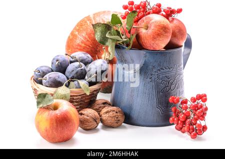 Mele in una brocca da giardino e altri frutti su sfondo bianco con ombra morbida Foto Stock