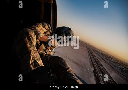 Personale Dominic Brinker, 66th Rescue Squadron (RQS) missioni speciali istruttore aviatore, aiuta i piloti per l'atterraggio alla base dell'aeronautica militare di Nellis, Nevada, 28 aprile 2022. La missione del sistema RQS 66 è fornire forze di ricerca e salvataggio in combattimento agili, rapide e dispiegabili in risposta alle operazioni di emergenza in tutto il mondo. Foto Stock