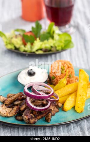 Gyros greci su un piatto con patatine fritte Foto Stock