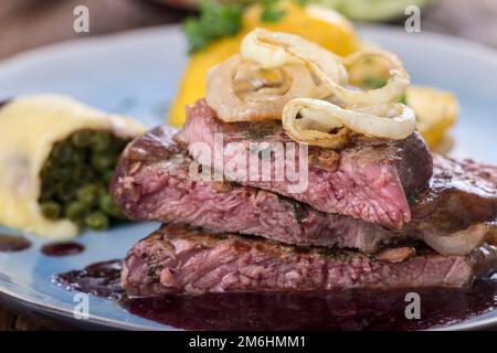 Bistecca con cipolle fritte Foto Stock