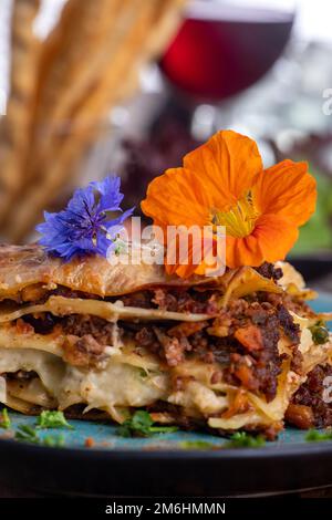 Lasagne fresche su piatto blu Foto Stock