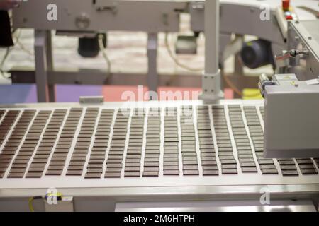Linea per la produzione di cioccolato in fabbrica industriale. Processo automatico nella linea di produzione delle caramelle durante la produzione. Co Foto Stock