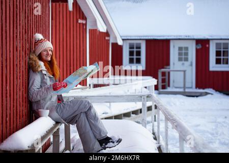 ragazza turistica con una mappa si trova vicino rorbu Foto Stock