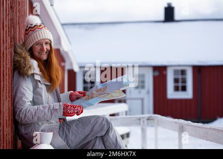 ragazza turistica con una mappa si trova vicino rorbu Foto Stock