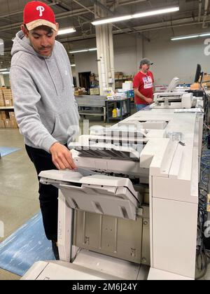 Sam Liriano, Electronic Equipment Operator, in primo piano verifica lo stato delle stampe a colori dalla Digital Press 770 con Michael Ciepiela, Supervisory Production Specialist, in background presso il controller. 28 aprile 2022. Foto di Nutan Chada, DLA Public Affairs. DLA,documento,servizi,Filadelfia, Foto Stock