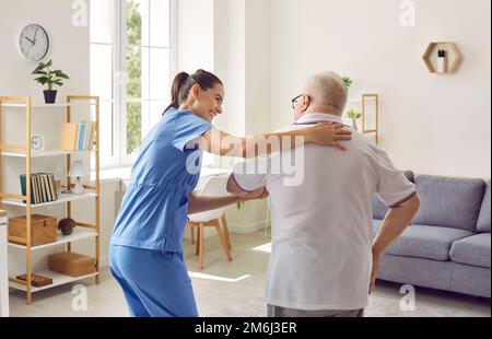Donna che assiste la paziente anziana con disabilità Foto Stock