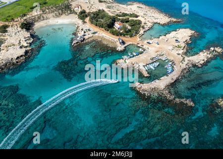 Drone aereo di pesca motoscafo che entra e ormeggiato al porto. Foto Stock