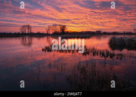 Cielo colorato e nuvole dopo il tramonto su un lago ghiacciato Foto Stock