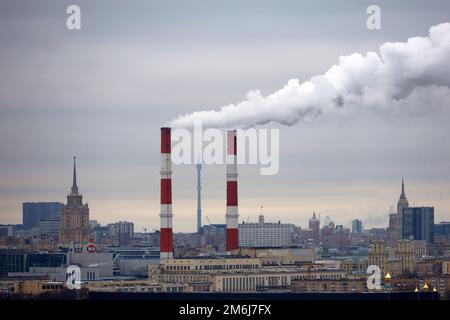 Tubi con fumo sopra Mosca in inverno. Concetto di ecologia e inquinamento atmosferico Foto Stock