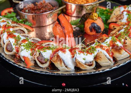 Cucina turca tradizionale Sarma Beyti Kebab. Turco e arabo tradizionale Ramadan alimentare Kebap Beyti Sarma con yogurt, che serve pane lavash all'interno Foto Stock