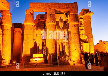 Visitatori sconosciuti visitano le statue del grande faraone nel Tempio di Luxor. Foto Stock