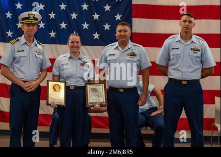 Jason Smith, a sinistra, comandante, settore della Guardia Costiera Houston-Galveston, Chief Petty Officer Michael Weisman, al centro a destra, E Chief Petty Officer Nickolas Meegan, a destra, presente Petty Officer 1st Classe Kailea Blankenship, a metà sinistra, con un settore Houston-Galveston arruolato persona dell'anno e United States Coast Guardsman's Creed targa durante una cerimonia a base Galveston, Texas, 28 aprile 2022. Durante la cerimonia, Blankenship, il piccolo ufficiale delle operazioni alla Stazione della Guardia Costiera di Galveston, è stato riconosciuto come la persona arruolato della Guardia Costiera dell'anno 2021 ed è stato meritoriosamente advan Foto Stock