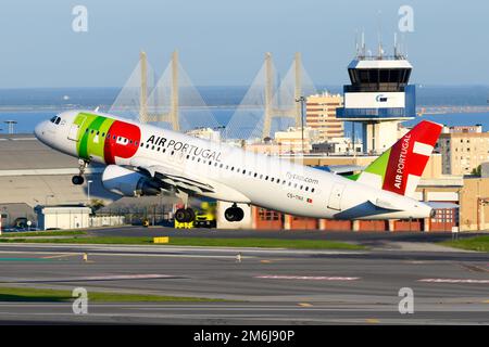 TAP Air Portugal Airbus A320 aereo decollo dall'aeroporto di Lisbona con Vasco da Gama Bridge dietro. Aereo di TAP e Torre ATC di Lisbona. Foto Stock