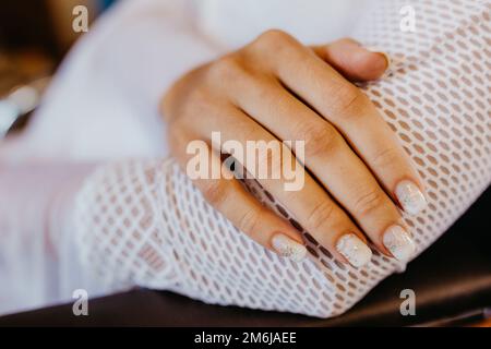 Un primo piano di una mano femminile con bella manicure in un giorno di nozze Foto Stock