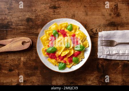Ravioli con salsa di pomodoro e basilico. Un piatto di pasta farcita Foto Stock