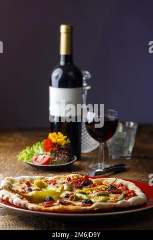 Pizza fresca con vino rosso Foto Stock