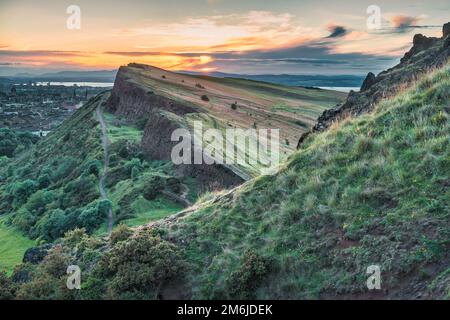 Salisbury Crags e Holyrood Park a Edimburgo, Scozia al tramonto Foto Stock