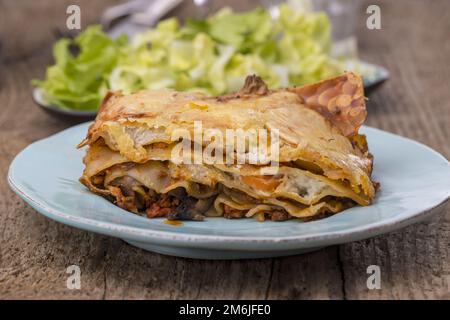 Lasagne con insalata di legno scuro Foto Stock