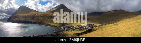 Villaggio di Gjógv sotto le montagne Tyril, Middagsfjall e Slættaratindur Foto Stock