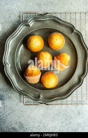 Mini cupcake alla vaniglia su sfondo di cemento Foto Stock