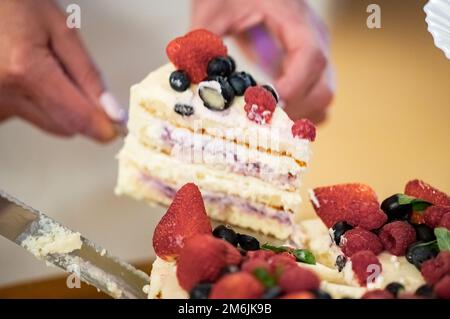 Donna che taglia la torta Foto Stock