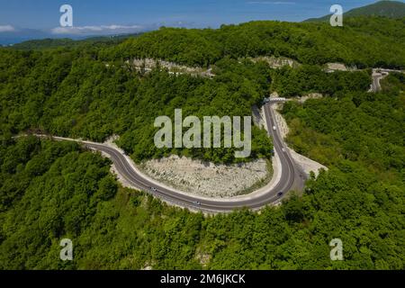 Vista aerea di automobili su una strada curva in montagna Foto Stock