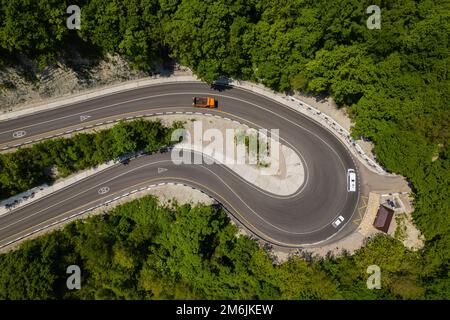 Vista aerea di automobili su una strada curva in montagna Foto Stock