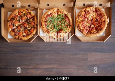 Tre diversi tipi di pizze in scatole di consegna Foto Stock