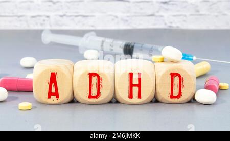 Abbreviazione ADHD su blocchi di legno. L'ADHD è un disturbo da deficit di attenzione e iperattività. Primo piano. Vignetta Foto Stock