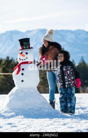Due ragazze che costruiscono un pupazzo di neve a Stateline, Nevada. Foto Stock