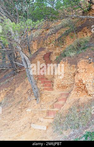 Un colpo verticale di una scala di legno su una scogliera rossa, Vrgada, Croazia Foto Stock