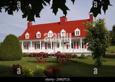 Due piani bianco con rifiniture rosse casa in stile Canadiana in estate, Sainte-Famille, Ile-d'Orleans, Quebec, Canada. Foto Stock