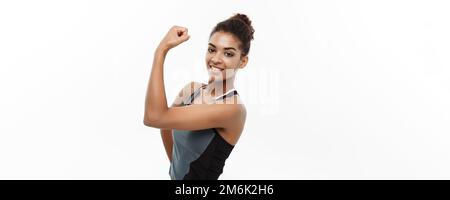 Concetto sano e Fitness - Ritratto di giovane bella African American mostrando il suo forte muscolo con fidato allegro fac Foto Stock