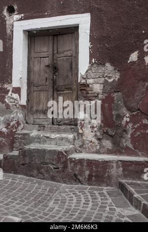 Un edificio intatto con scale in pietra e una porta di legno - il concetto di povertà Foto Stock