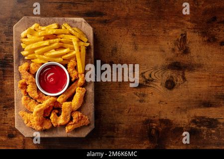 Pollini, pepite impanate, con un tuffo al barbecue e patatine fritte Foto Stock