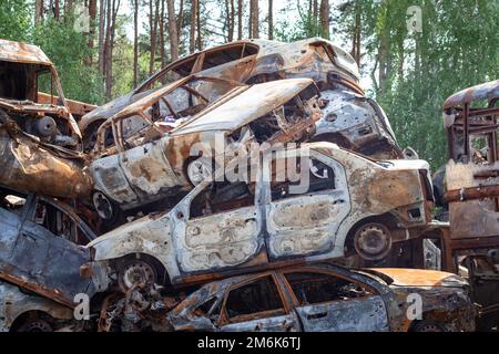 L'invasione russa dell'Ucraina nel 2022, distrusse e bruciò le automobili. Le automobili sono state picchiate con shrapnel e bruciate. Auto Irpensky c Foto Stock