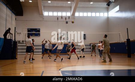 Gli airmen della 18th Wing giocano a pallavolo durante le prime Olimpiadi annuali di Dorm alla base aerea di Kadena, Giappone, 29 aprile 2022. Ogni partecipante ha guadagnato punti per il dormitorio rappresentato in ogni evento e tutti i punti sono stati contati alla fine della settimana per determinare il dormitorio vincente. Foto Stock