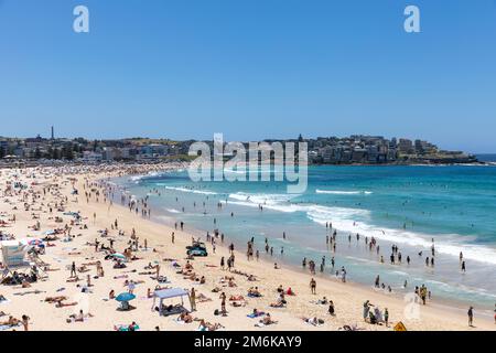 2023 Bondi Beach in un giorno di estate dal cielo limpido, la spiaggia è affollata di bagnanti e persone che si rilassano nuotando nella vista sull'oceano Nord, Sydney, NSW, Australia Foto Stock