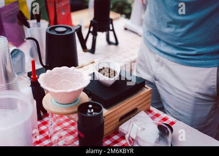 Il barista peserà i chicchi di caffè sulla bilancia digitale. Foto Stock